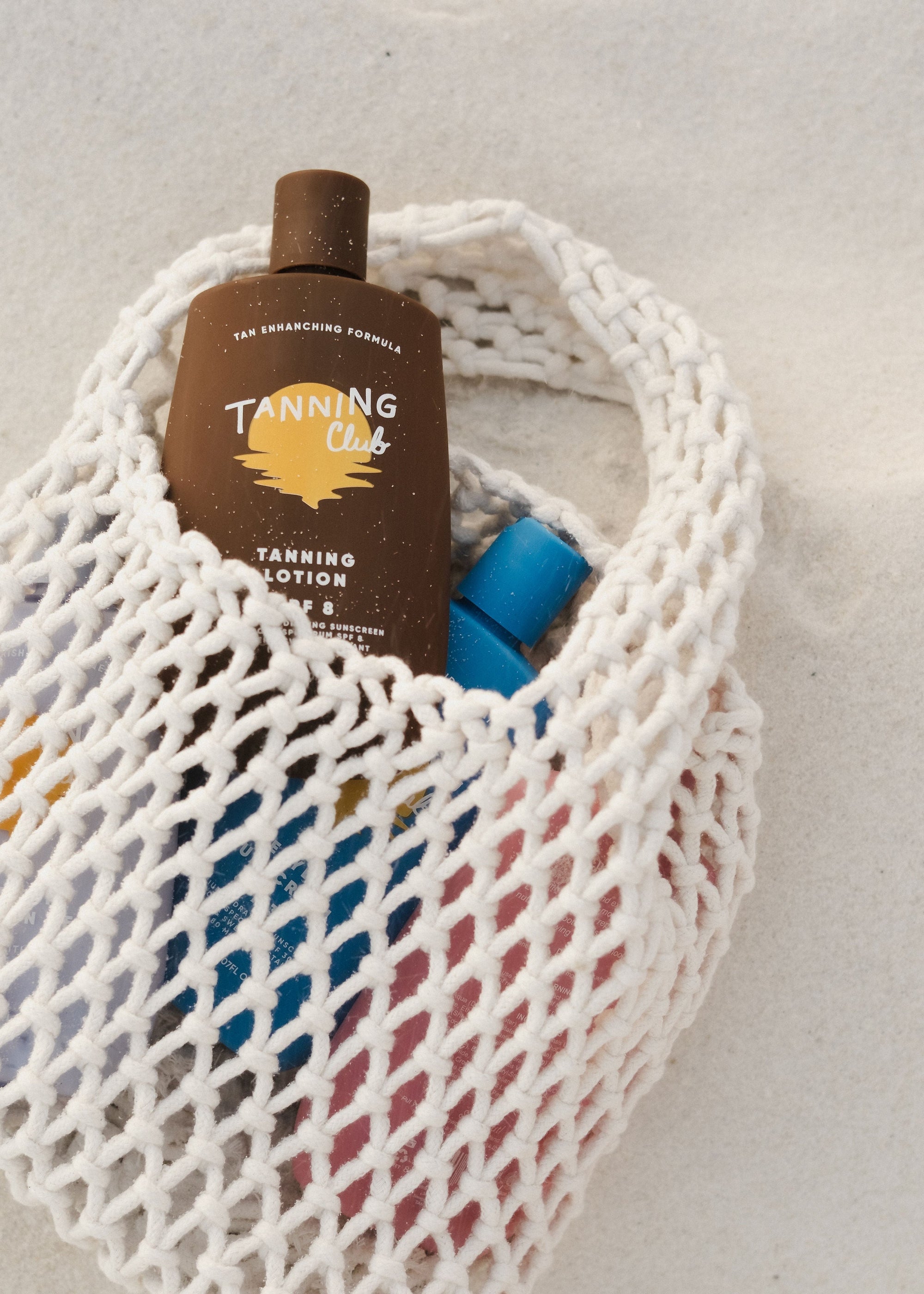 Surfboard resting in the back of a white convertible parked near the ocean, with clear skies and coastal greenery in the background.